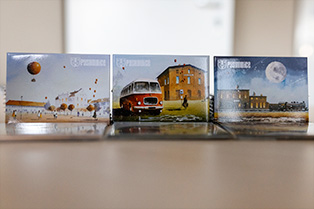 zdjęcie 3 magnesów z grafikami autorstwa Grzegorza Chudego; pierwszy przedstawia rynek pyskowicki z balonami,  dwa przedstawiają Stację Kultury  w róznych ujeciach (na jednym z stary autobus 