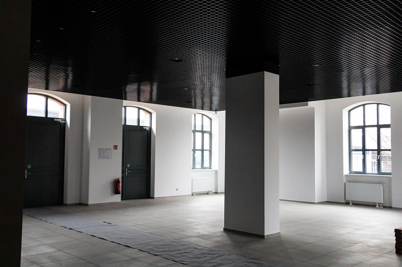 wnętrze dworca, białe puste pomieszczenie z filarem