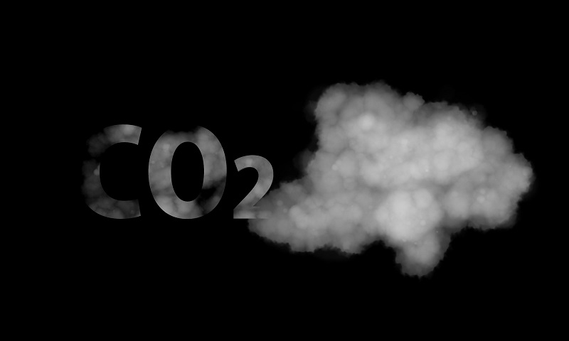 Czarne niebo, na nim obłok dymu i ułożony z niego symbol CO2