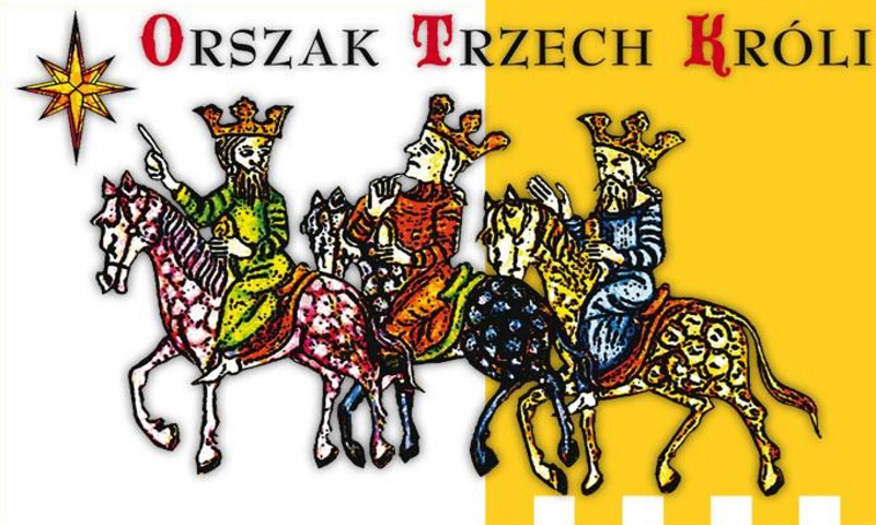 Na biało - pomarańczowej szachownicy trzech jeźdców, w zdobnych szatach (żółtej, czerwonej i niebieskiej), w koronach kierują się na zachód, dokąd prowadzi gwiazda.