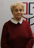 Starsza kobieta, w siwych, krótkich włosach, w wiśniowym, dzianym swetrze, z wyłożonym kołnierzem białej bluzki. Zdjęcie portretowe