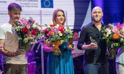 Rafał Kozok z nagrodą i bukietem kwiatów (stoi po prawej, wysoki, młody mężczyzna bez włosów). Obok mężczyzna i kobieta z kwiatami - pozostali laureaci konkursu 