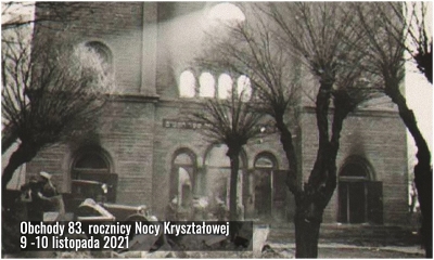 Na czarno-białym zdjęciu zgliszcza synagogi, wypalona frontowa część z powybijanymi oknami, na dole gruzowisko.
