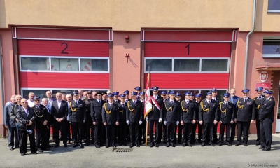 Zdjecie zbiorowe strażaków ubranych na galowo, stojących na placu przed siedzibą Jednostki Ratowniczo - Gasniczej w Pyskowicach