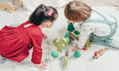 Dwójka dzieci, chłopczyk i dziewczynka, bawi się na podłodze klockami